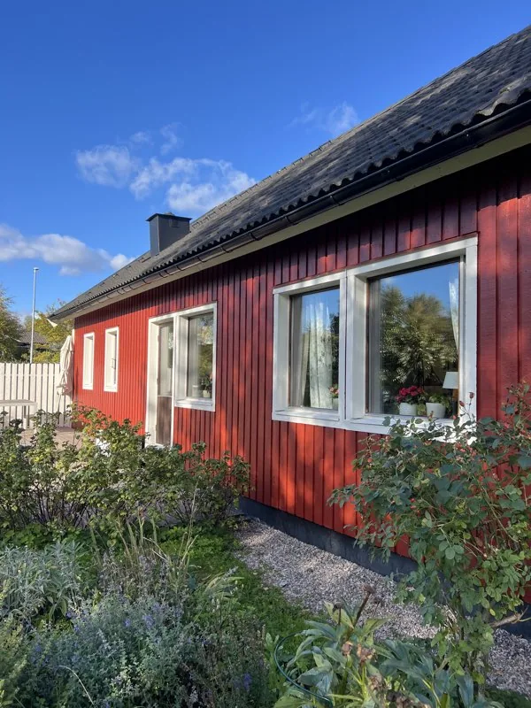 Rena fönster på rött hus med blå himmel